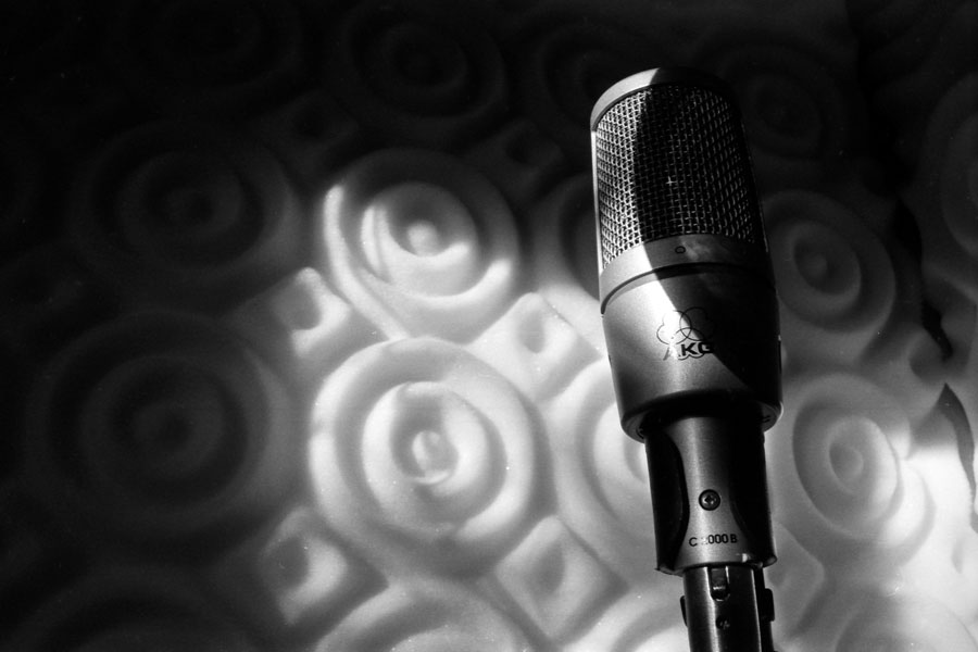 A window lit microphone in a vocal booth.